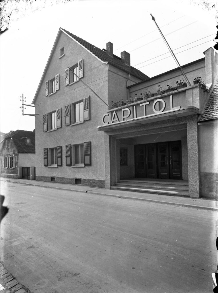 Das Foto zeigt das Gebäude des Hochheimer Kinos "Capitol". Über dem Eingang befindet sich der Schriftzug des Kinos. Das Gebäude ist an einer ruhigen Straße gelegen.